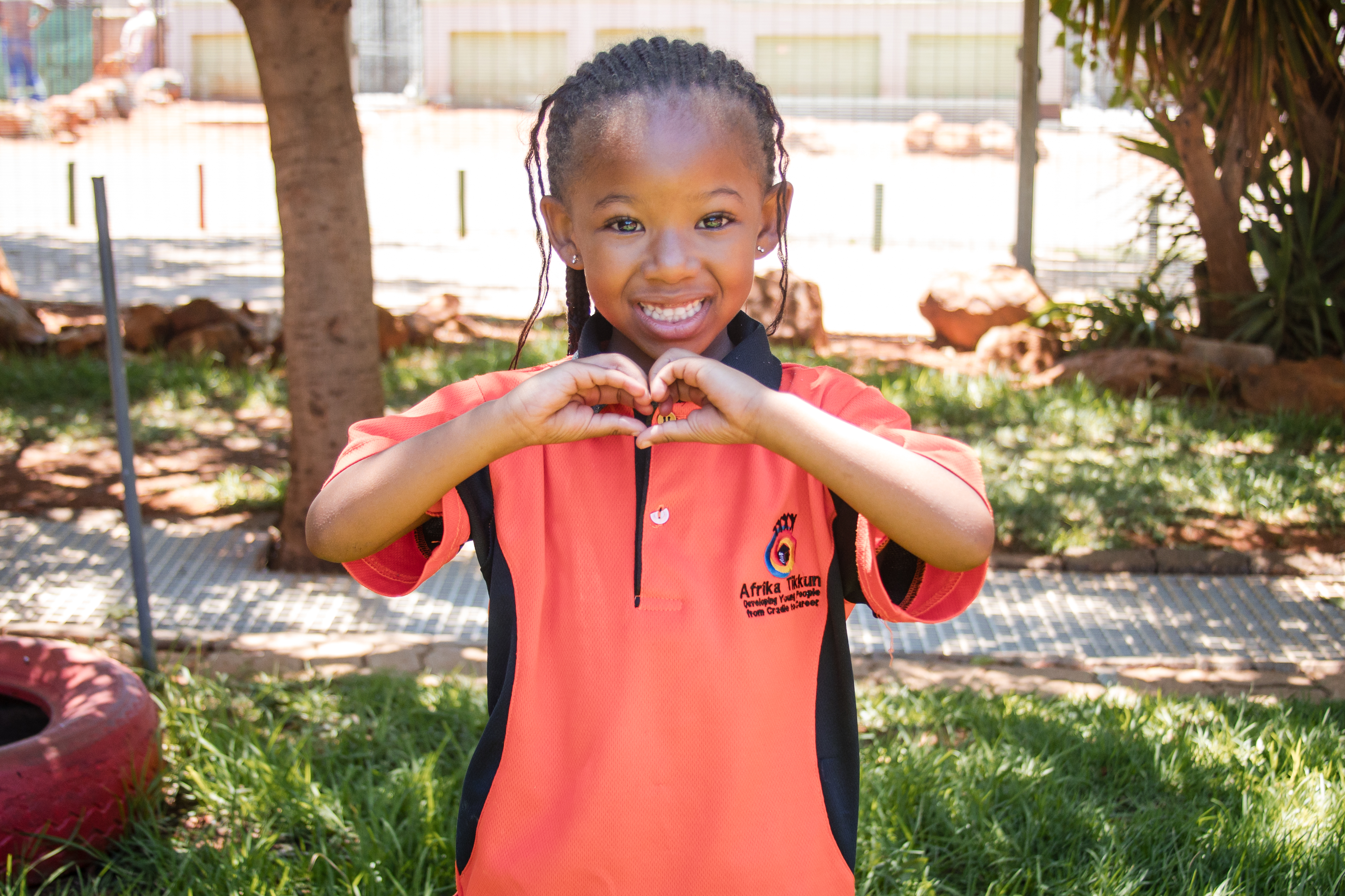 A child holding a heart-shaped craft at an Afrika Tikkun centre